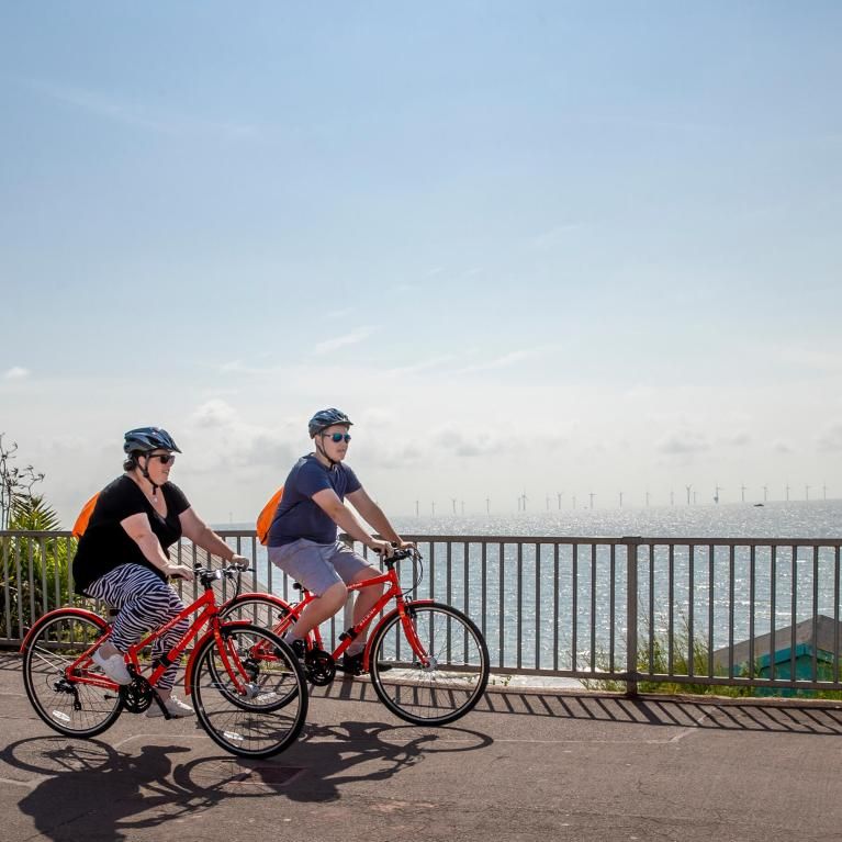 Two riders cycling along the coast