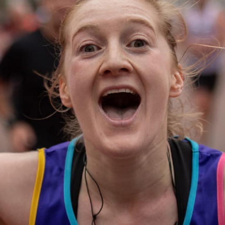 A runner celebrates after finishing the Virgin Money London Marathon