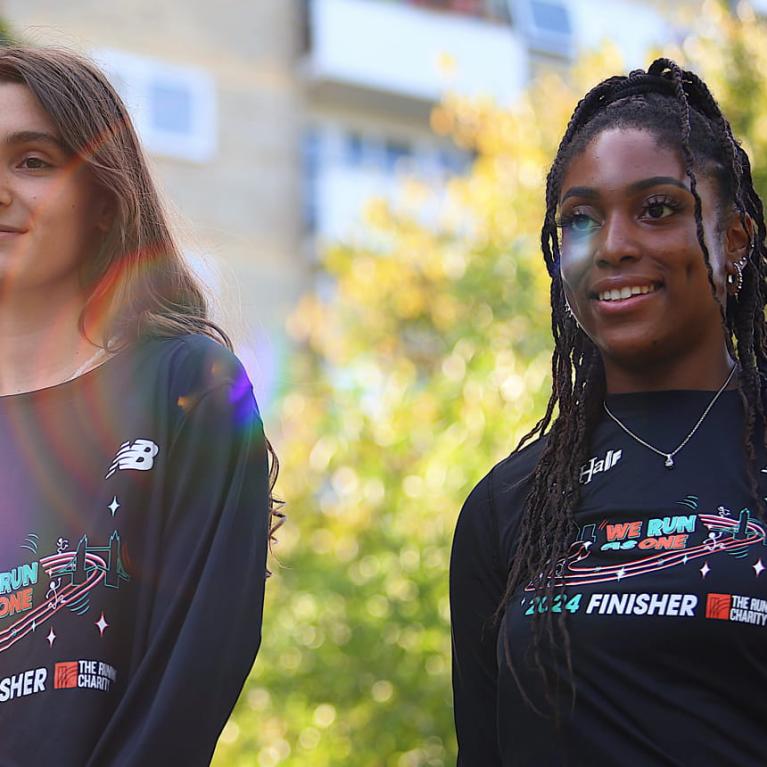 Two women wearing the 2024 The Big Half communities' t-shirt