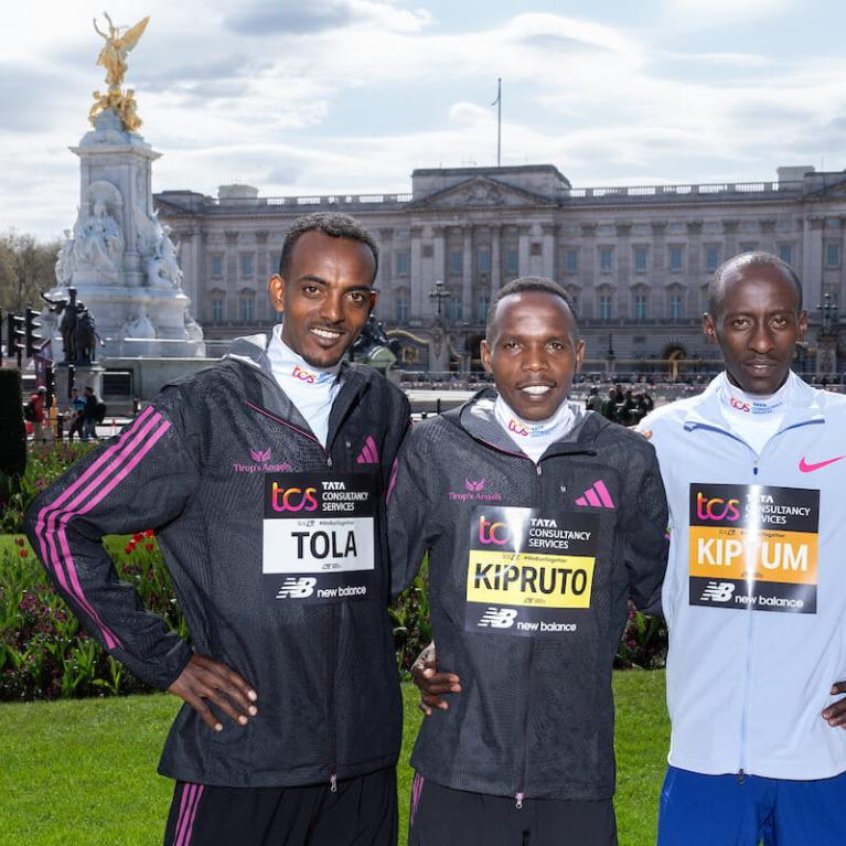 Three elite athletes in front of Buckingham Palace