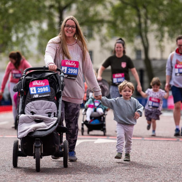 Children, adults and buggies make their way down The Mall in central London