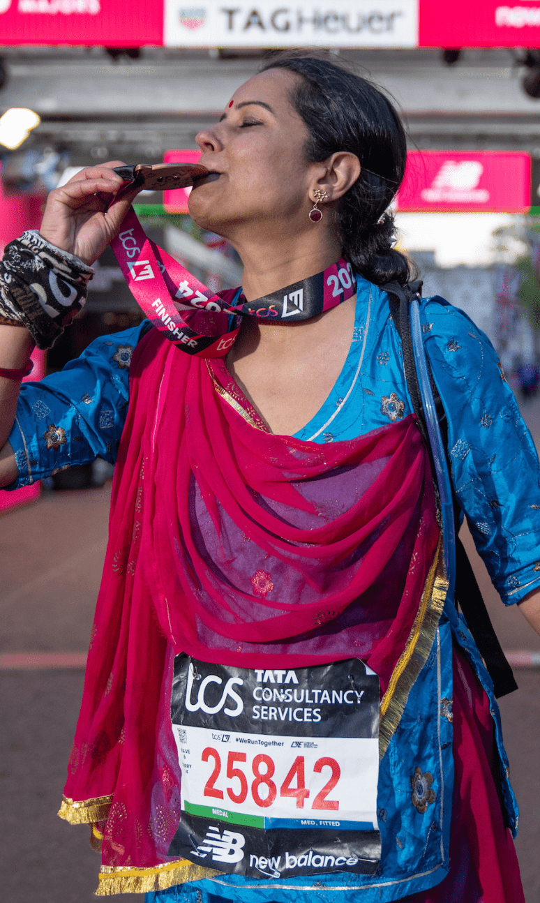 person kissing their medal at the London marathon finish line 