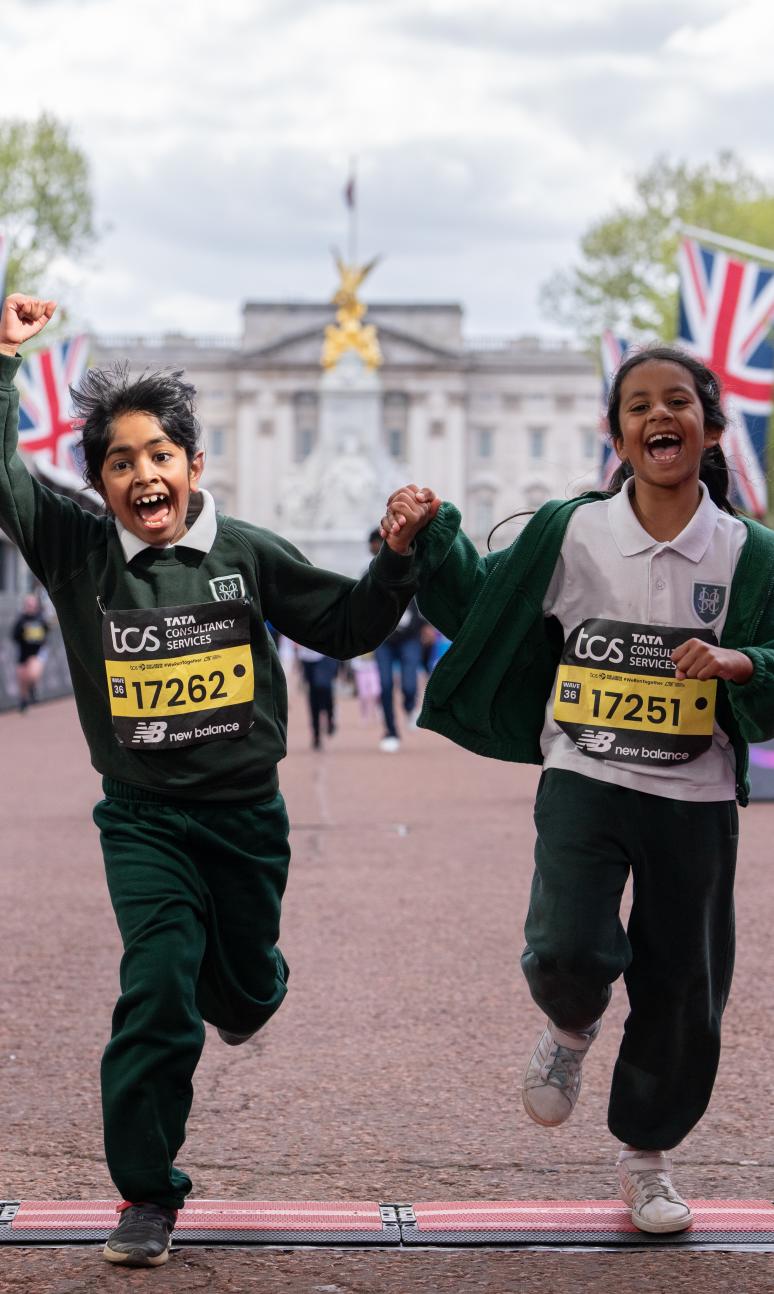 2 children running over the finish line celebrating