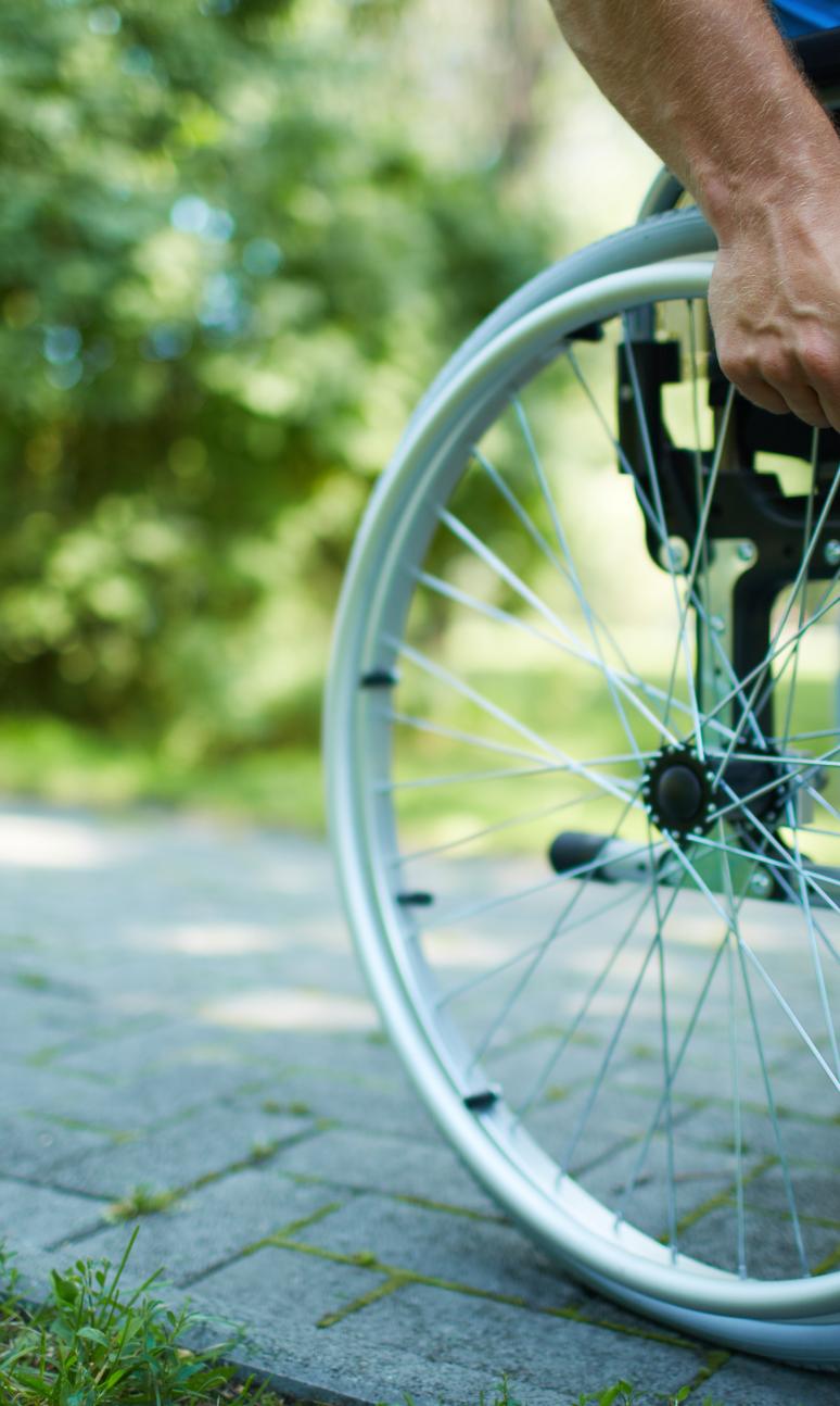 Wheelchair user pushing themself through a park