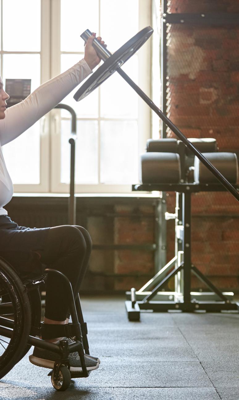 Wheelchair user in the weights area of the gym