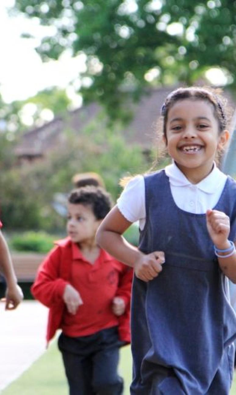 School children running on a running track at school