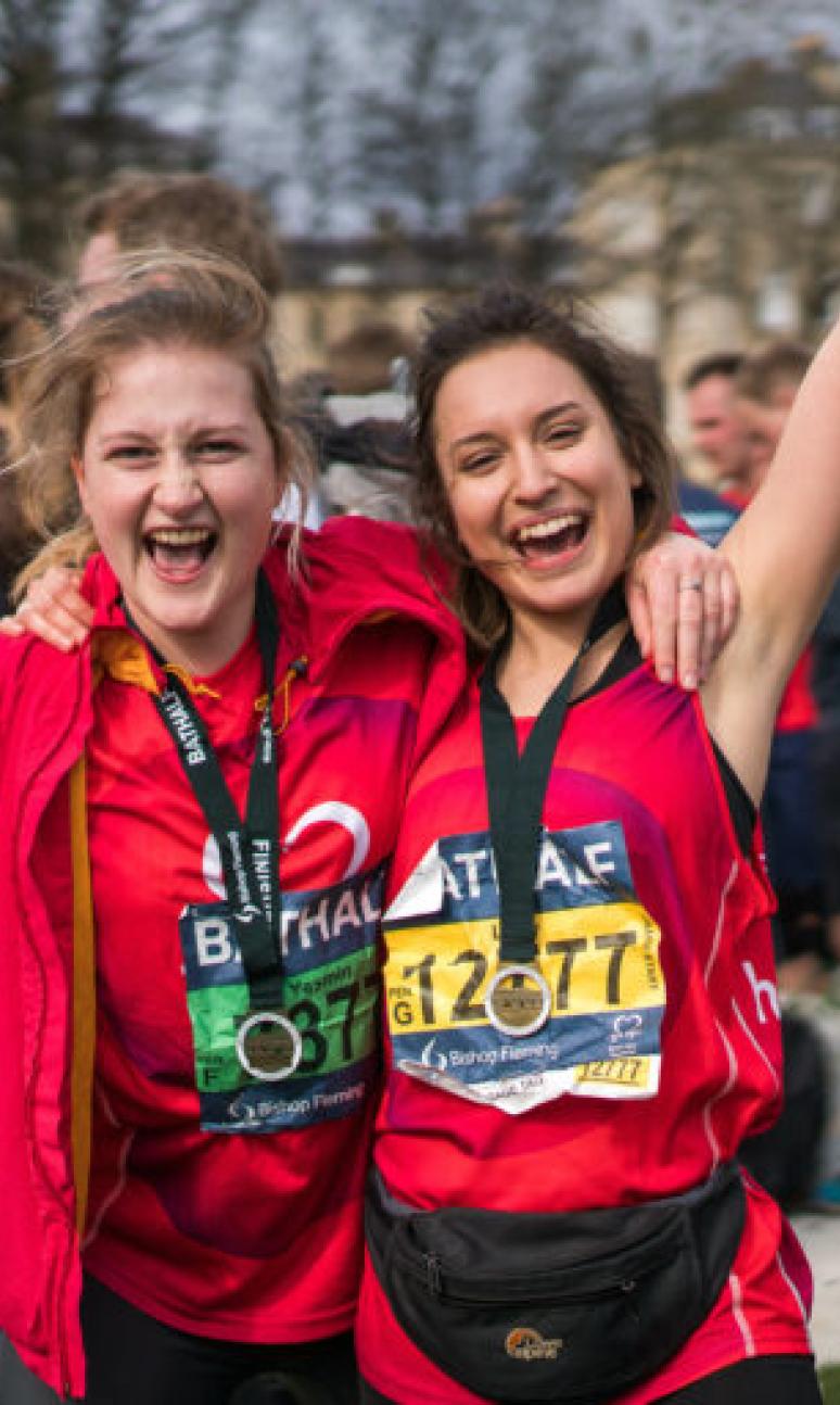 Two participants pose with their medals after their race