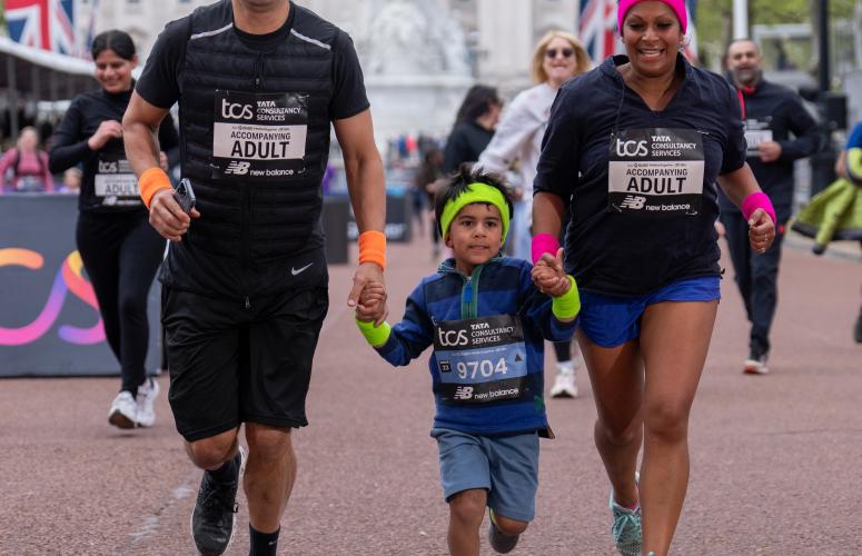 A mum and dad running the race with their child in the middle of them