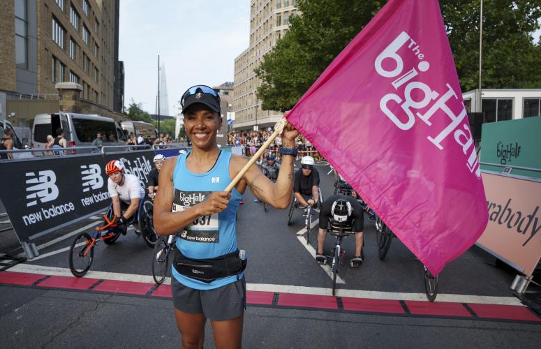 Woman holding a flag at the finish line of the big half