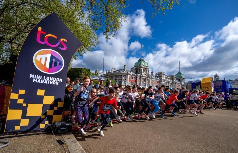 Multiple children running off the start line of the race