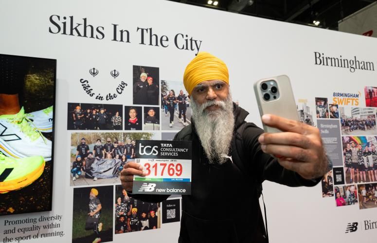 A runner poses for a photo with their bib number 