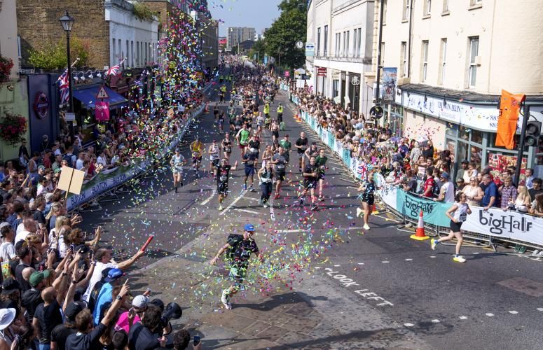 Big Half participants run through ticker tape as they near the Finish Line