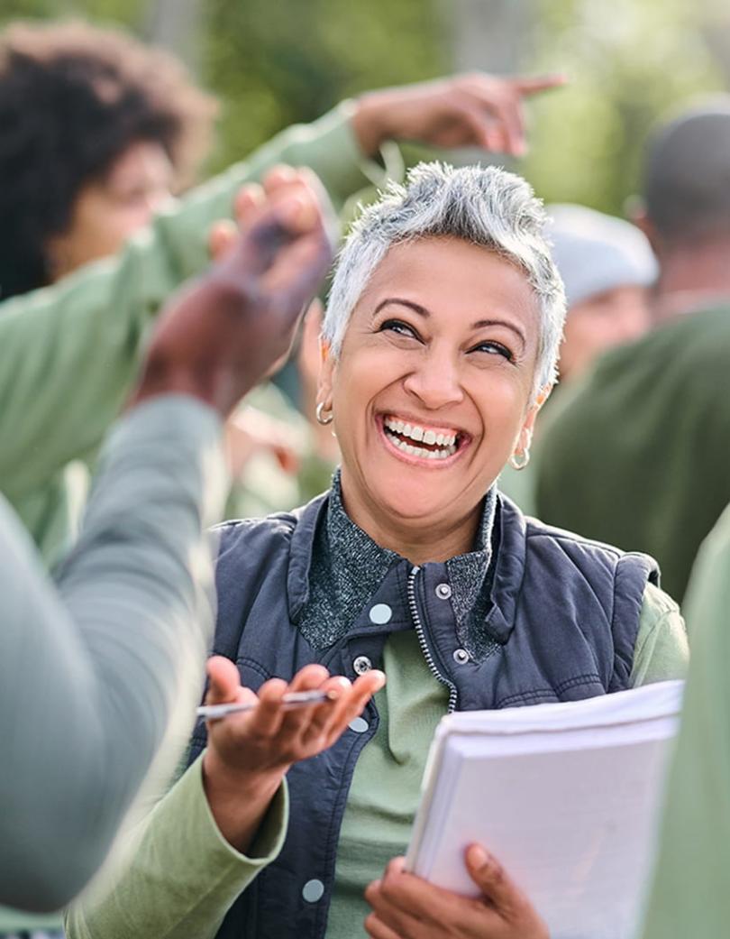 Woman smiles as she explains things to others