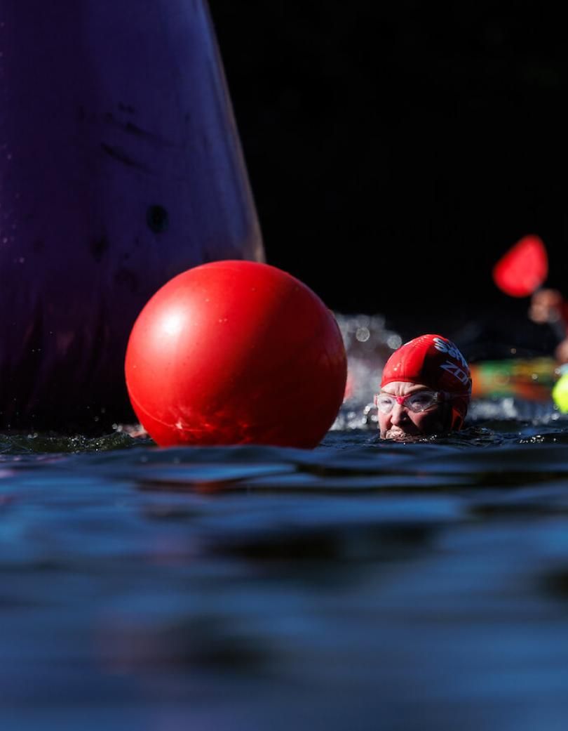 A swimmer shot from water level in front of a safety buoy