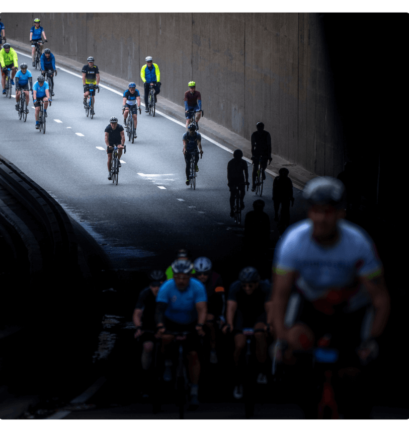 Cyclist emerge from riding under a bridge in central London