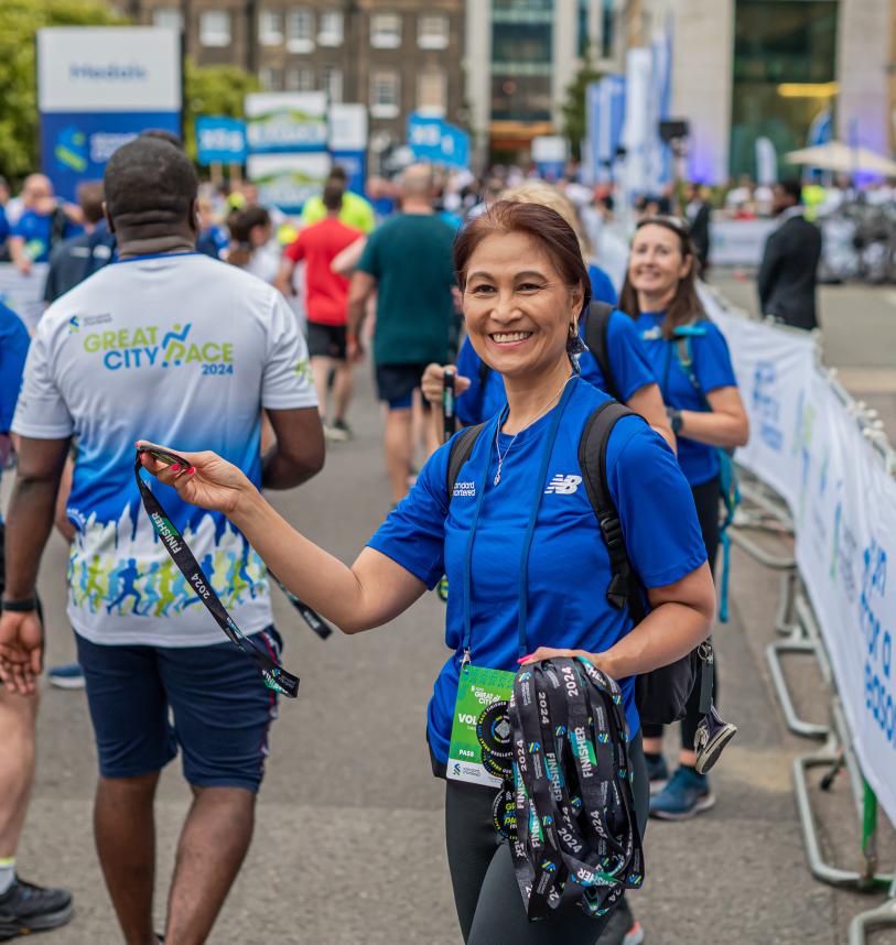 Great City Race volunteer handing out medals