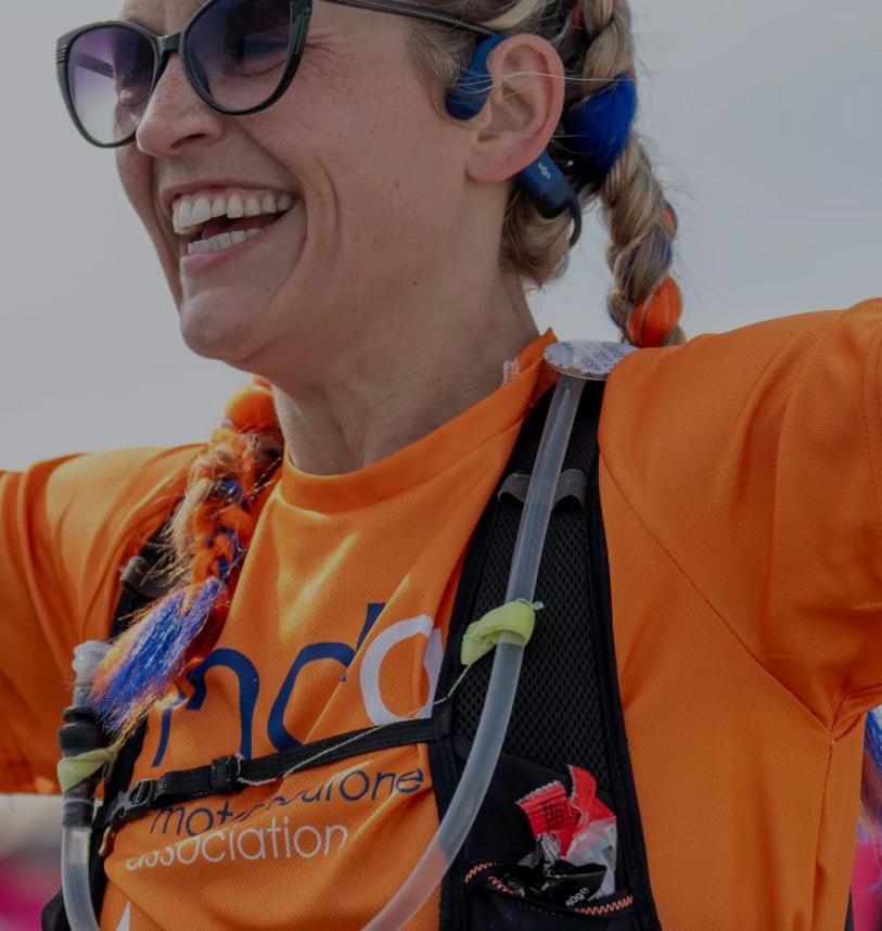 A close up of a runner with her arms in the air as she nears the finish line