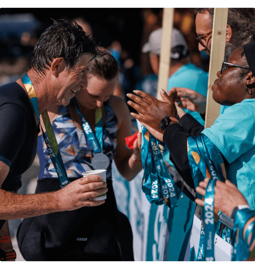 A volunteer hands a participant his medal