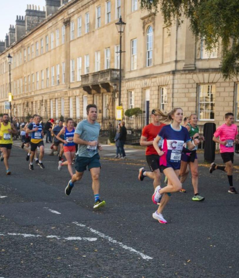 A Cancer Research runner smiles at the camera during their event