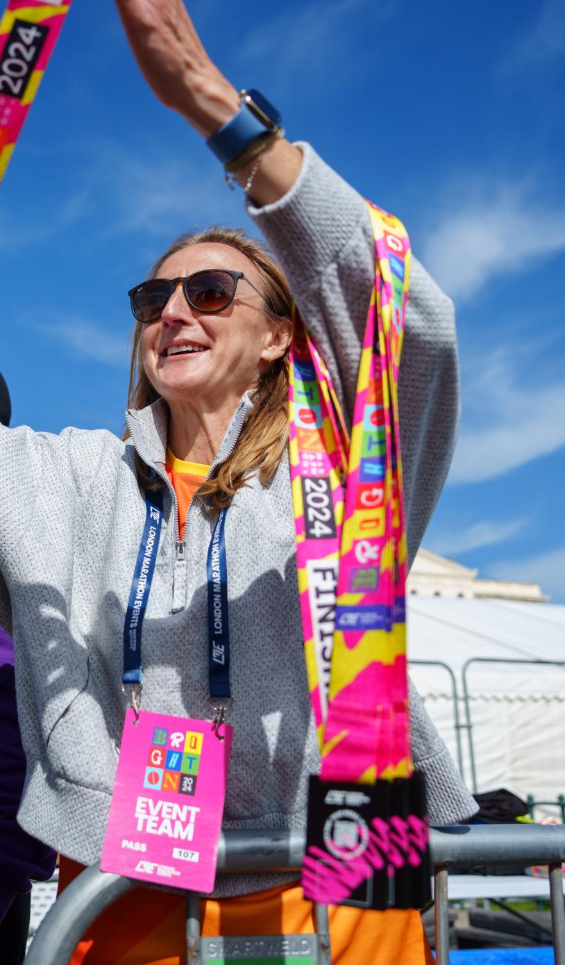 Woman hands medal to participant at the Brighton marathon