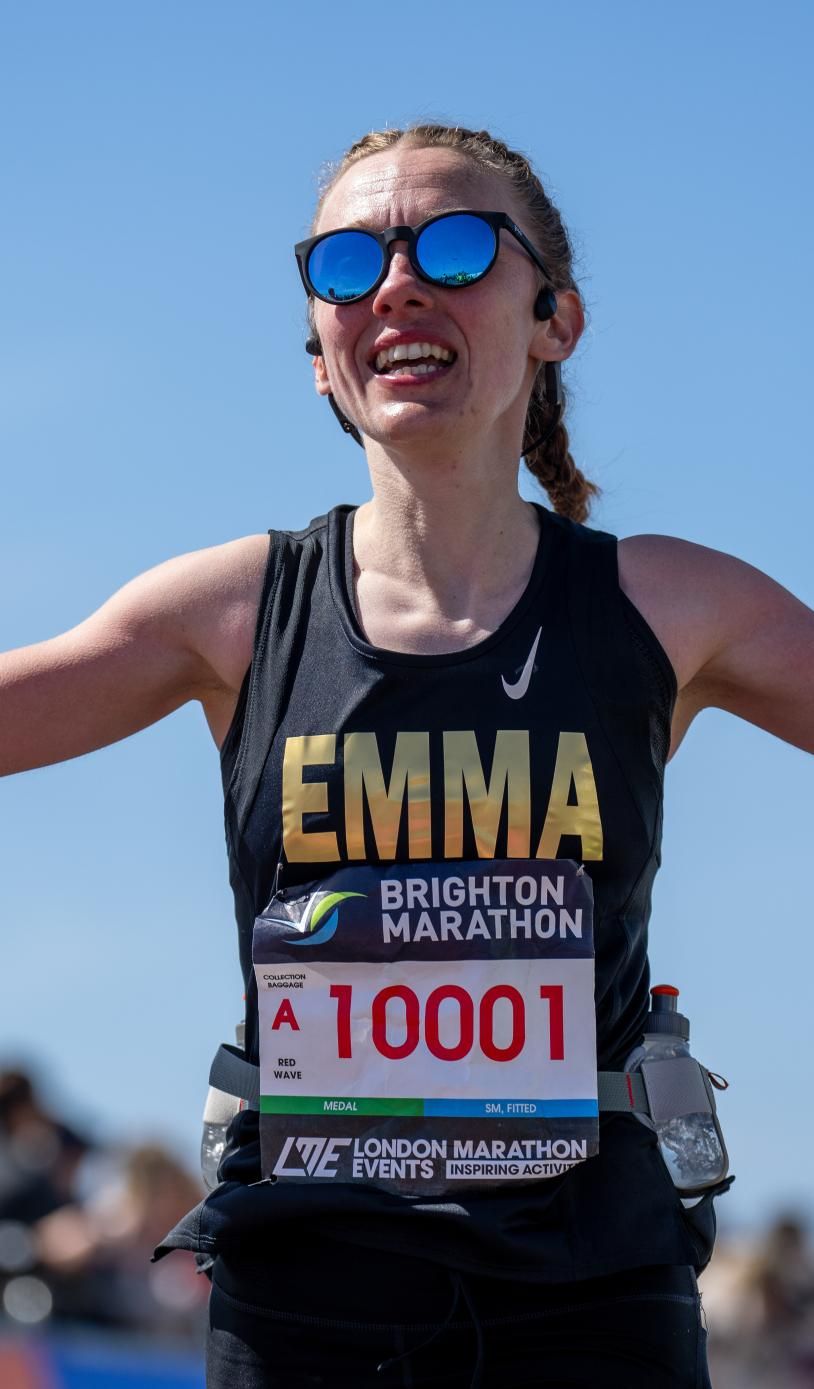 Woman holds up hands as she runs the Brighton marathon