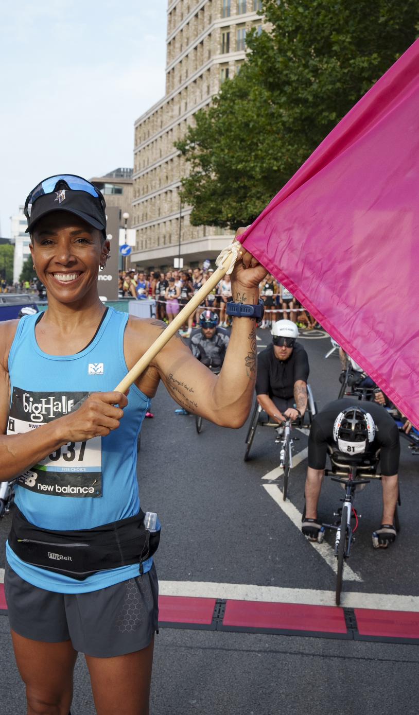 Woman holding a flag at the finish line of the big half