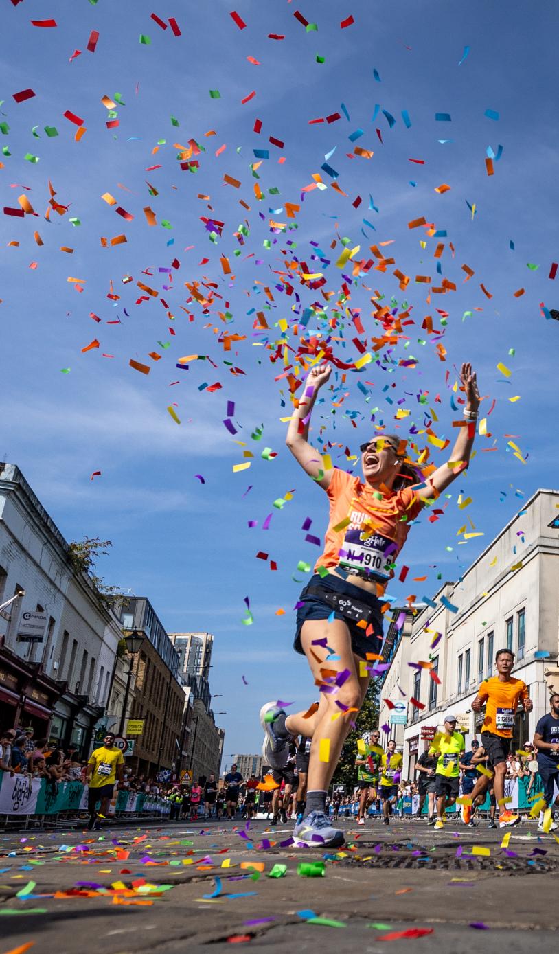 Big Half participant celebrates finishing the event in a cloud of confetti