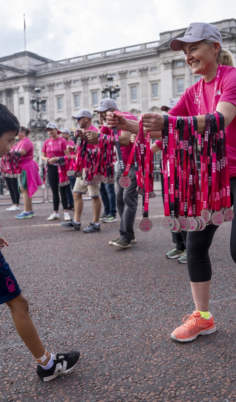 Volunteers hand out medal at the Westminster Mile Finish Line