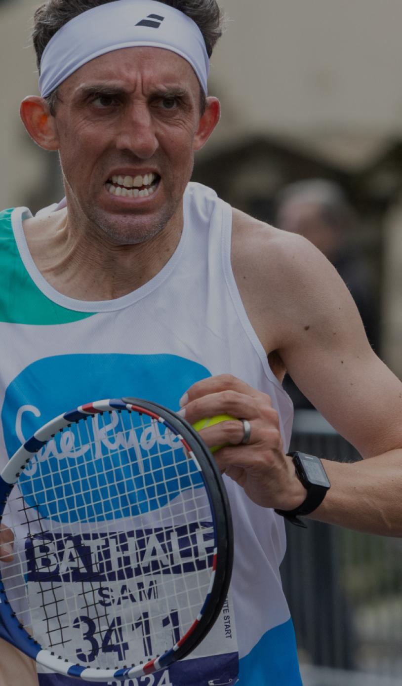 A runner dressed in fancy dress holding a tennis racket during the Bath Half