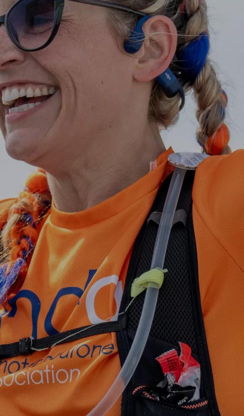 A close up of a runner with her arms in the air as she nears the finish line