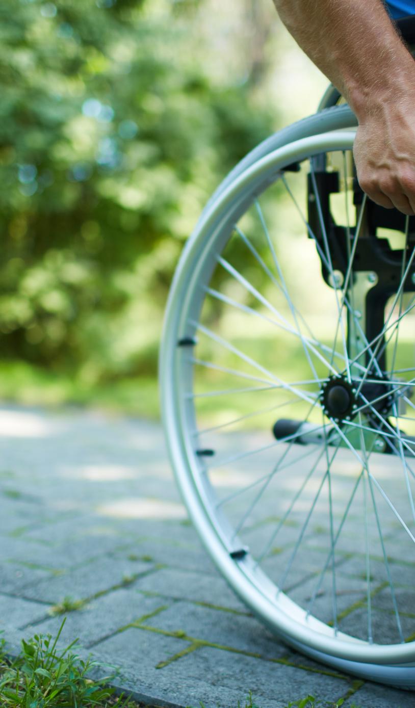 Wheelchair user pushing themself through a park