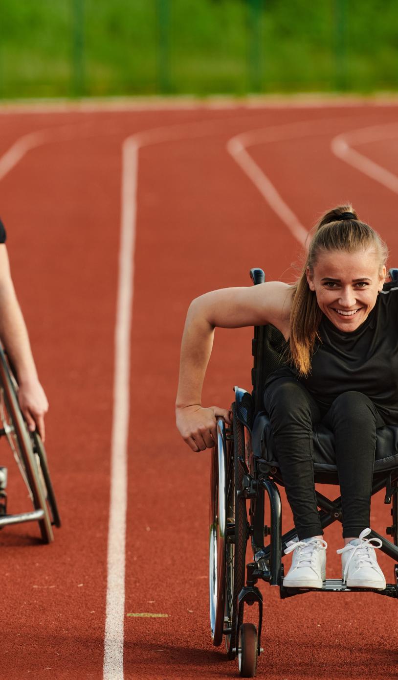 Two wheelchair users enjoying their outdoor track session