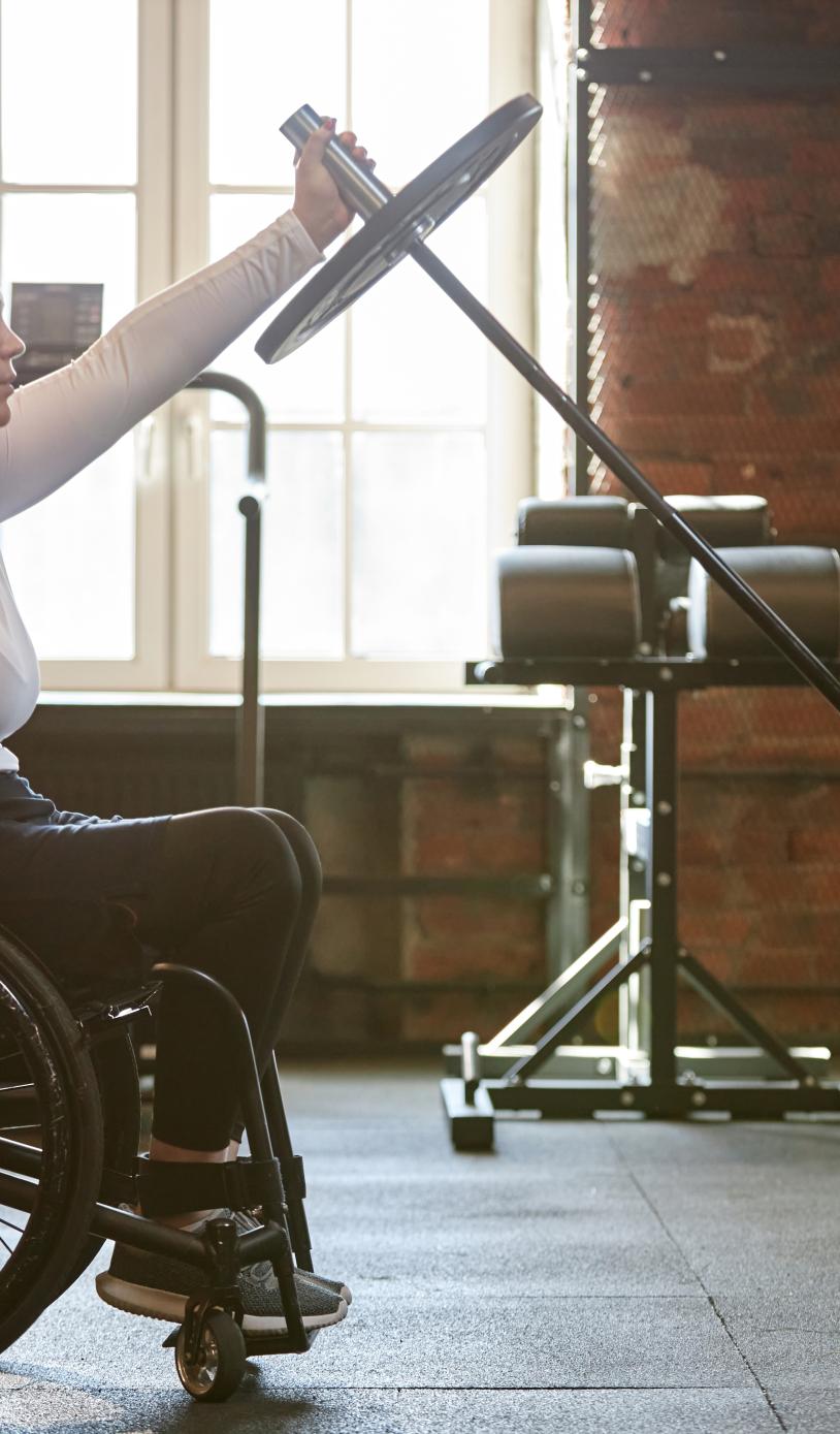 Wheelchair user in the weights area of the gym