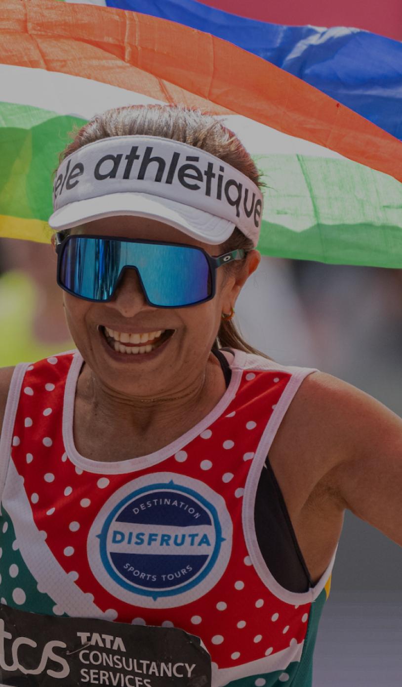 A participant waving a flag as they cross the finish line