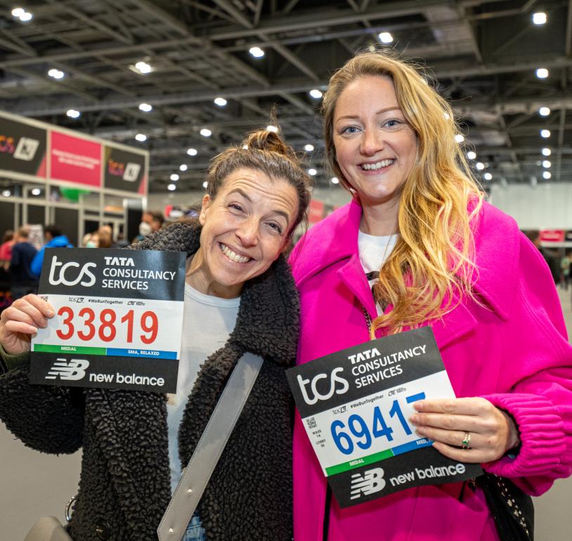 Runners pose for a photo with their bib numbers at the TCS London Marathon Running Show 