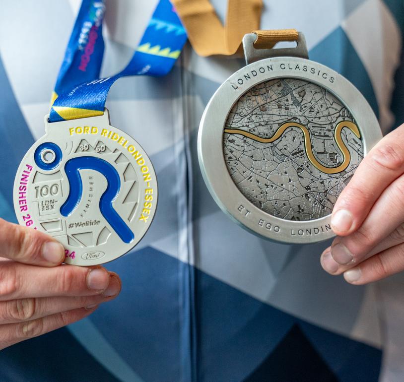 A person holding a London Classics and a RideLondon medal