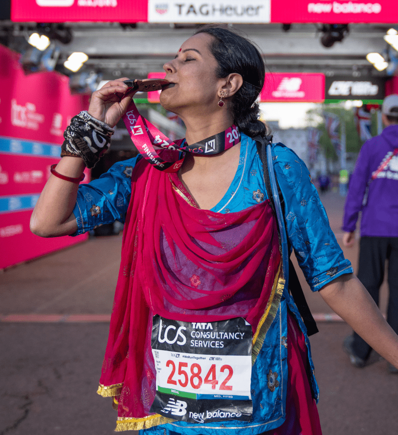 person kissing their medal at the London marathon finish line 