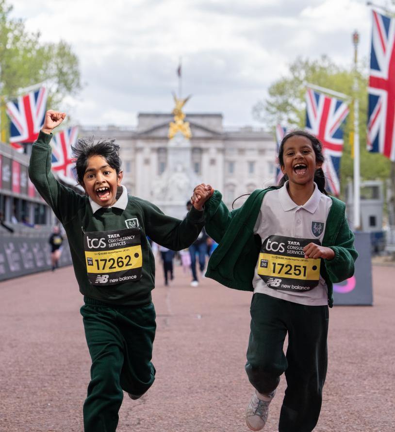 2 children running over the finish line celebrating